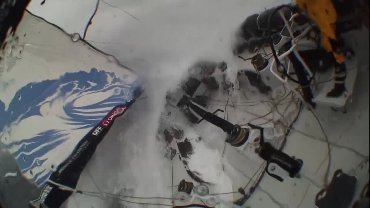 Crash cam / stern cam footage while TTToP surfs in high wind and big seas on starboard gybe. Lucas, on the helm, takes a big enough wave in the face that his PFD inflates. He hands off the helm to someone, then heads forward to go below (presumably to change out his life vest).